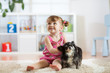 Child girl and her dog play in nursery