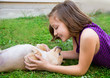 children girl playing with chihuahua dog lying on lawn